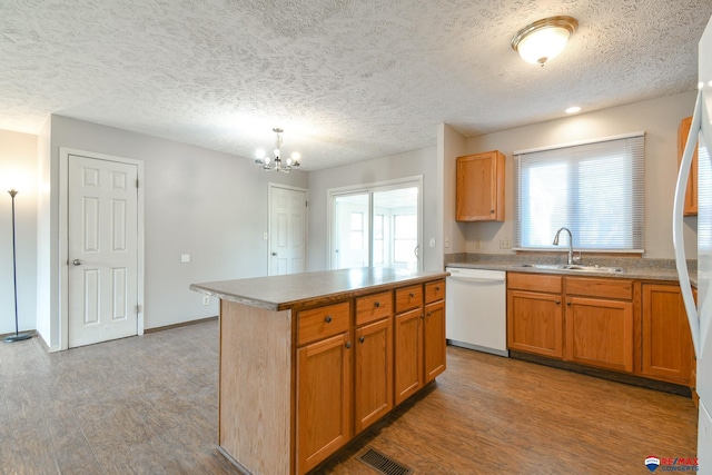 kitchen featuring a chandelier, a center island, white dishwasher, sink, and decorative light fixtures