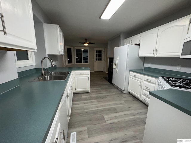 kitchen featuring sink, white appliances, ceiling fan, white cabinetry, and kitchen peninsula