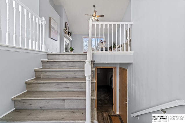 staircase featuring ceiling fan