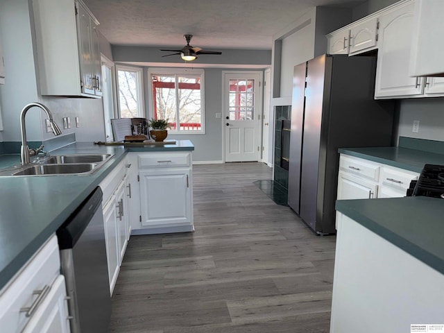 kitchen featuring dark hardwood / wood-style floors, white cabinetry, sink, ceiling fan, and stainless steel appliances