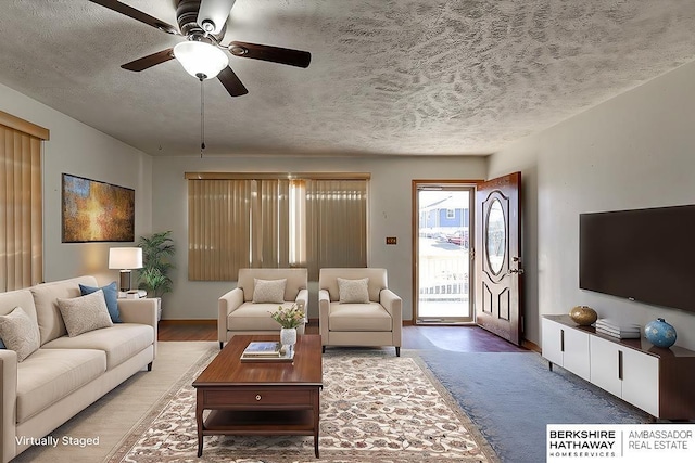 living room with ceiling fan and a textured ceiling