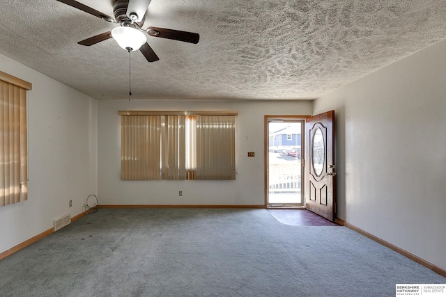 foyer entrance with carpet floors and ceiling fan