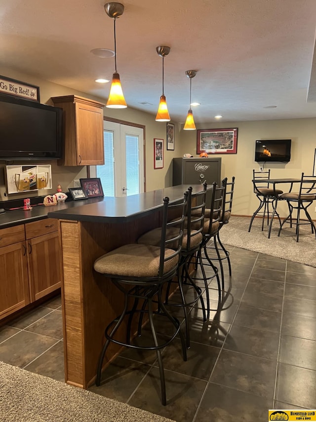 bar featuring hanging light fixtures, french doors, and dark carpet