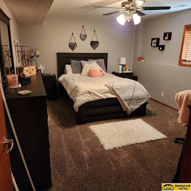 bedroom featuring ceiling fan, dark carpet, and a textured ceiling