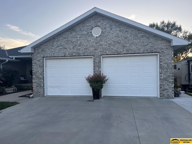 view of garage at dusk