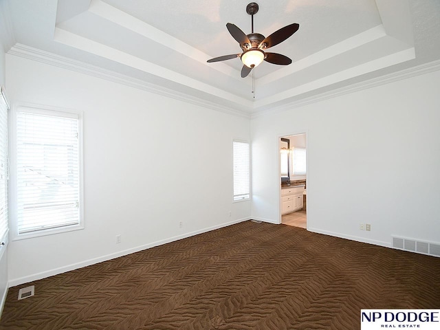 carpeted empty room with ceiling fan, ornamental molding, and a tray ceiling