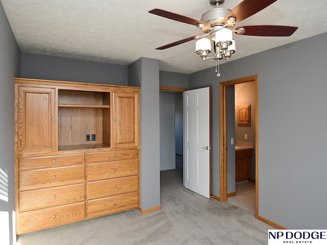 carpeted bedroom featuring a textured ceiling, ceiling fan, and connected bathroom