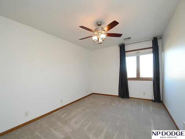 empty room with ceiling fan and light colored carpet