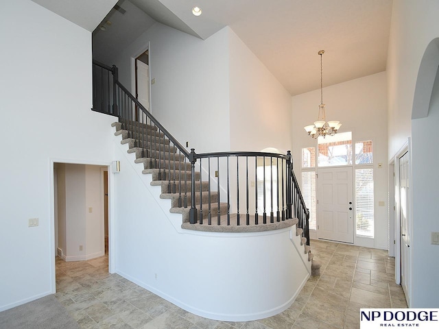 foyer entrance with a towering ceiling and a chandelier