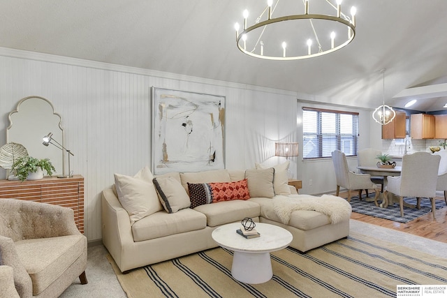 living room featuring light hardwood / wood-style floors, sink, lofted ceiling, and a chandelier