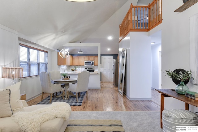 interior space with light hardwood / wood-style floors, high vaulted ceiling, and a chandelier