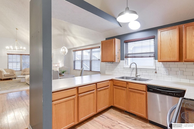 kitchen featuring pendant lighting, stainless steel appliances, a notable chandelier, lofted ceiling, and sink