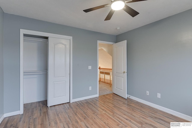 unfurnished bedroom featuring ceiling fan, light hardwood / wood-style flooring, and a closet