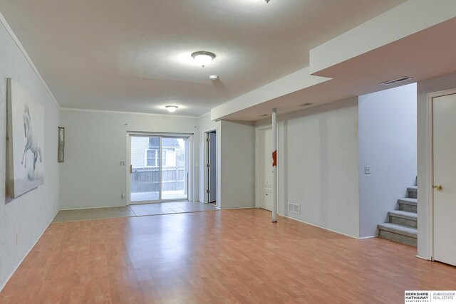 unfurnished room with light wood-type flooring and crown molding