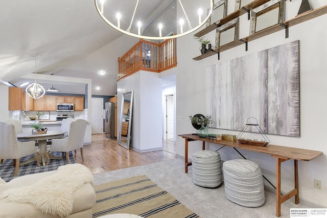 living room featuring sink, high vaulted ceiling, an inviting chandelier, and light colored carpet