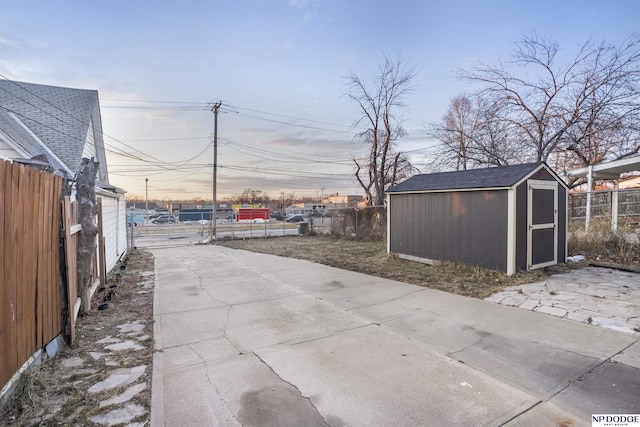 patio terrace at dusk featuring a storage unit