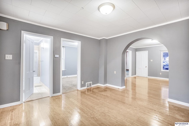 spare room featuring ornamental molding and light wood-type flooring