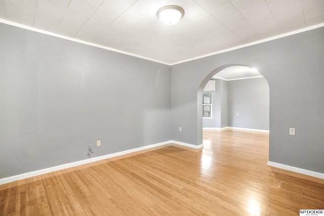 spare room with light wood-type flooring and ornamental molding