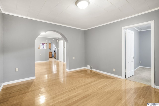 unfurnished room with light wood-type flooring and crown molding