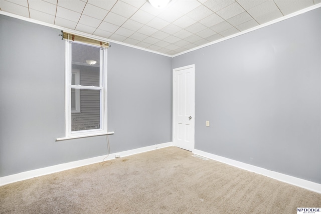 unfurnished room featuring ornamental molding and carpet