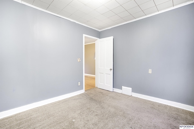 carpeted spare room featuring ornamental molding