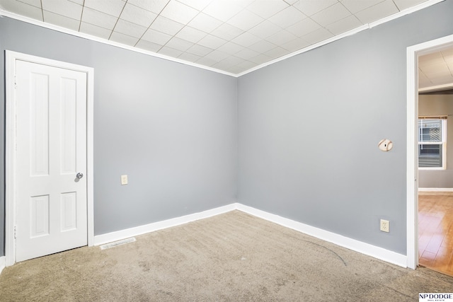 carpeted spare room with crown molding