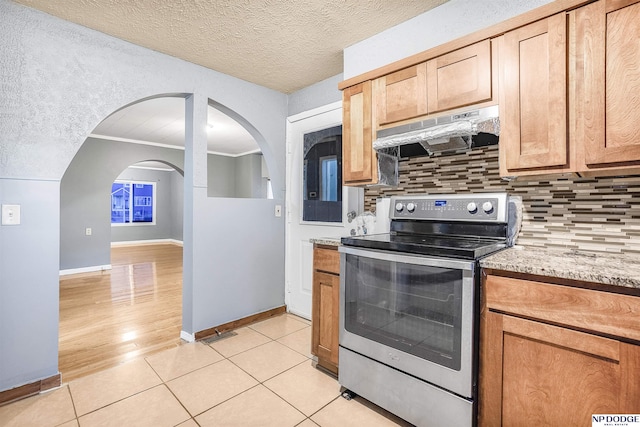 kitchen with stainless steel electric range, a textured ceiling, tasteful backsplash, and light tile patterned floors