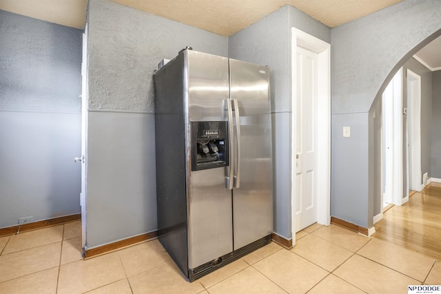 kitchen featuring stainless steel refrigerator with ice dispenser and light tile patterned flooring