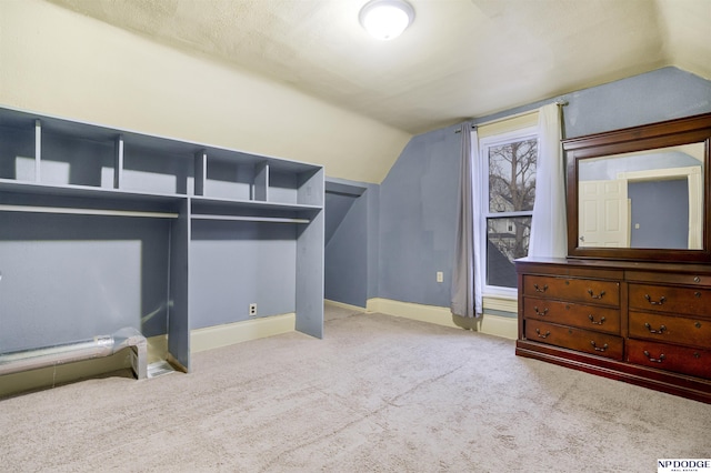 spacious closet with lofted ceiling and light colored carpet