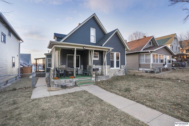 view of front of house with covered porch and a front lawn