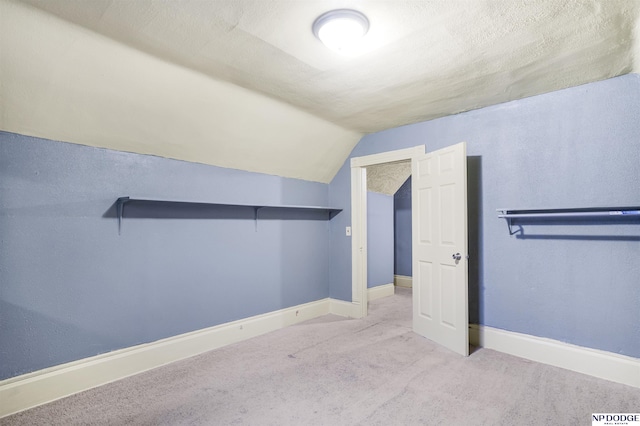 bonus room featuring lofted ceiling and light carpet