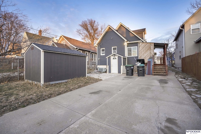 back of house with a storage unit