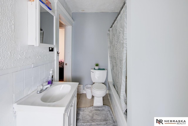 full bathroom with shower / bathtub combination with curtain, toilet, tile patterned floors, vanity, and a textured ceiling