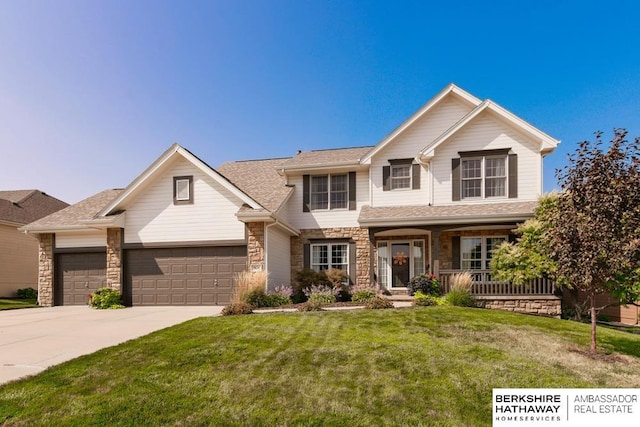 view of front of home with covered porch, a front lawn, and a garage