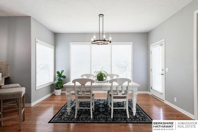 dining area featuring a healthy amount of sunlight, a chandelier, and hardwood / wood-style floors