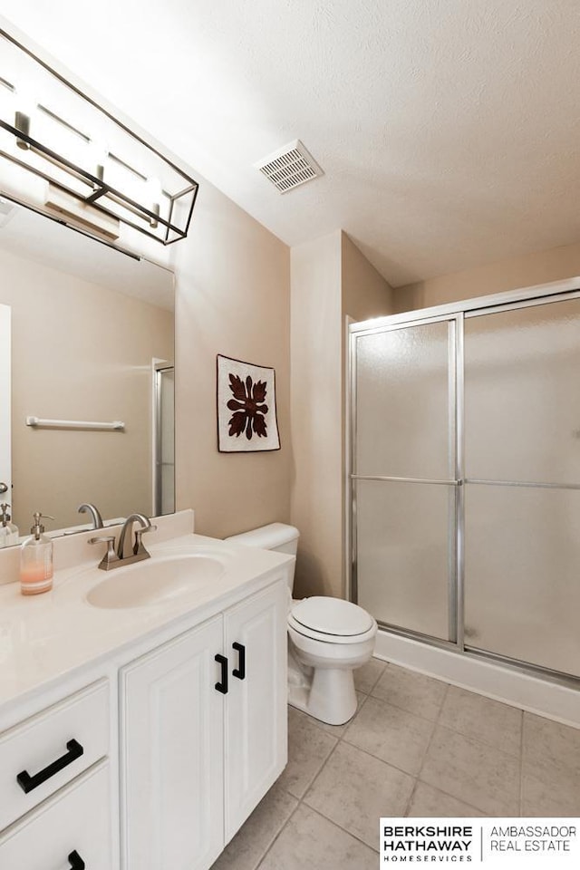 bathroom with toilet, vanity, and walk in shower