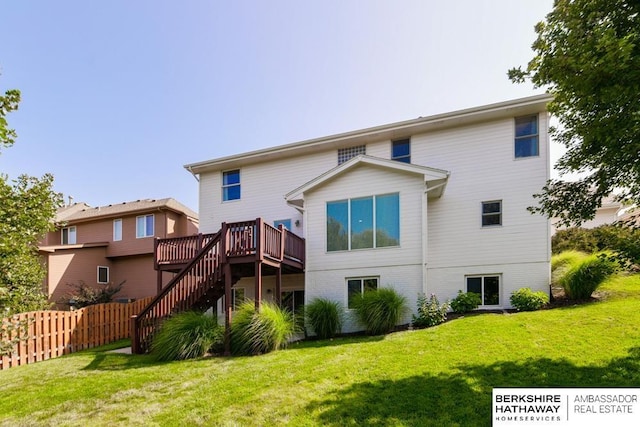 back of property featuring a lawn and a wooden deck