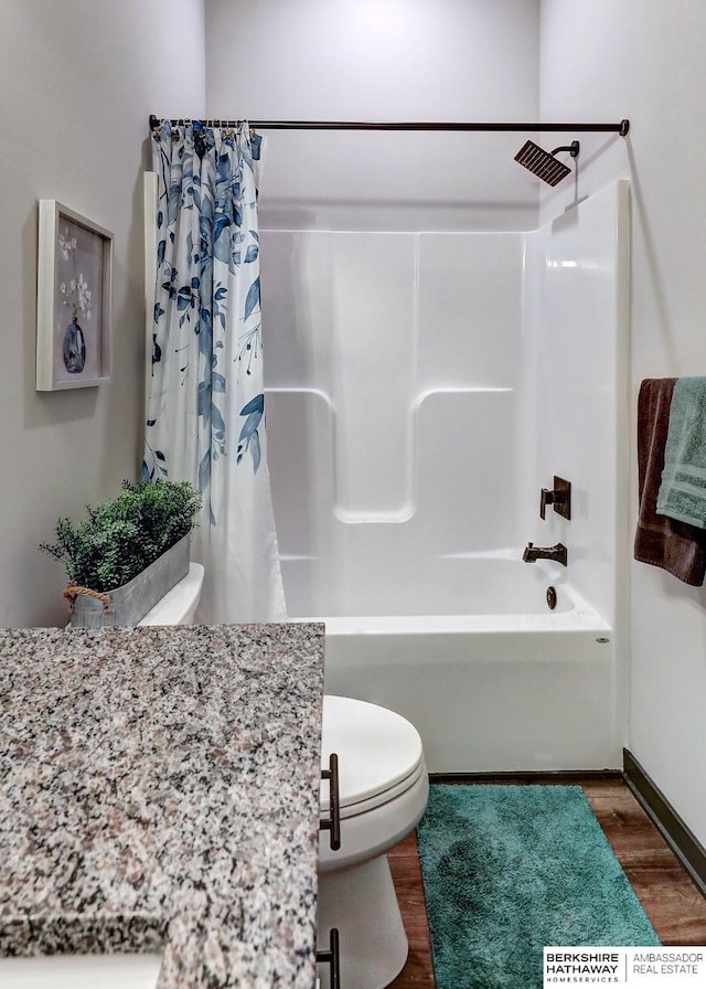 bathroom with toilet, hardwood / wood-style floors, and shower / bath combination with curtain