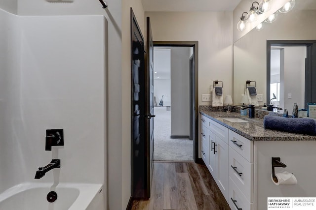 bathroom featuring bathing tub / shower combination, vanity, and wood-type flooring