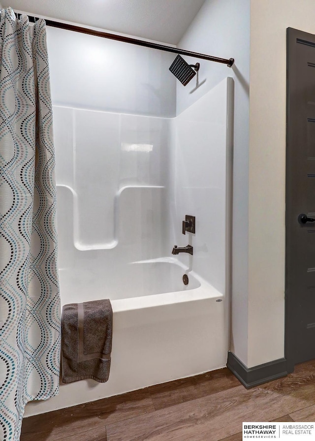 bathroom featuring hardwood / wood-style floors and shower / bath combo with shower curtain