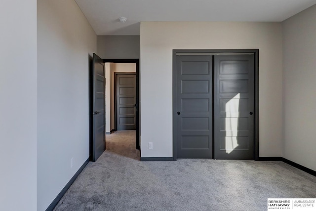 unfurnished bedroom with a closet and light carpet