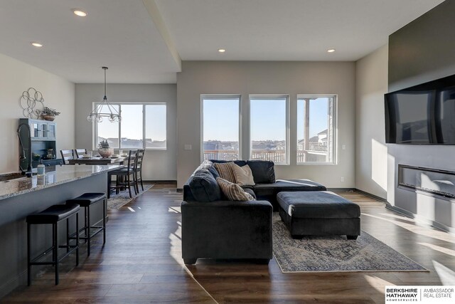 living room with dark hardwood / wood-style flooring and a notable chandelier