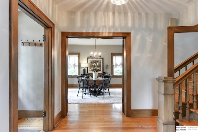 hall featuring an inviting chandelier and light wood-type flooring