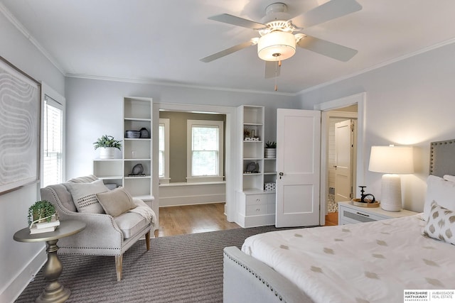 bedroom with ceiling fan, crown molding, hardwood / wood-style floors, and multiple windows