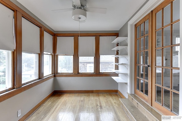 unfurnished sunroom with ceiling fan