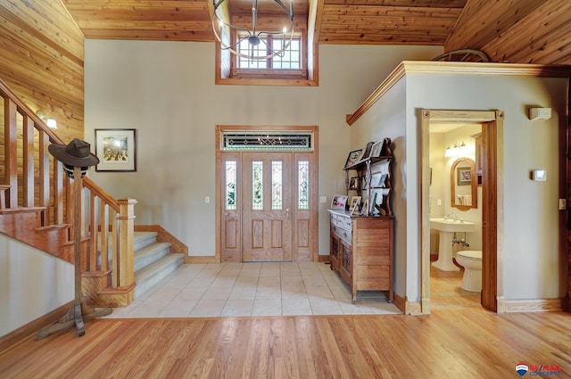 foyer with high vaulted ceiling, light hardwood / wood-style floors, and wooden ceiling