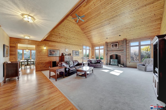 carpeted living room featuring high vaulted ceiling, ceiling fan, and wooden ceiling