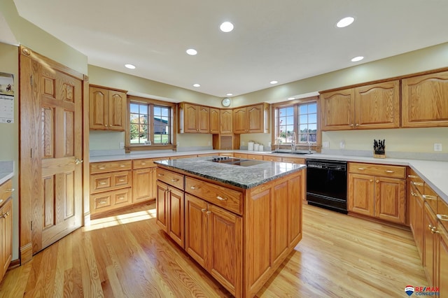 kitchen with black appliances, light hardwood / wood-style floors, a center island, and plenty of natural light