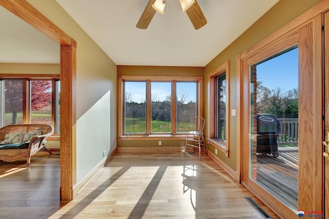 unfurnished sunroom with ceiling fan