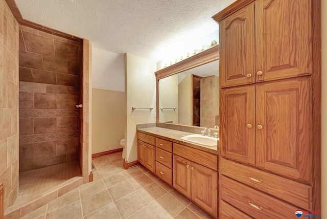 bathroom with tile patterned flooring, toilet, vanity, a shower, and a textured ceiling